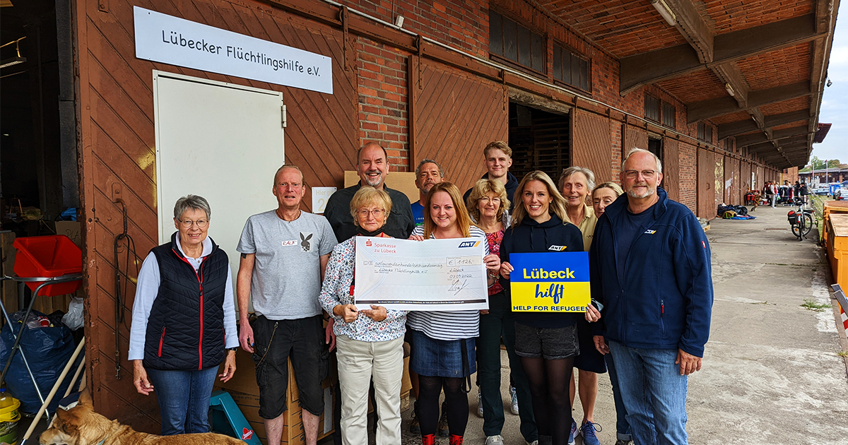 ANT spendet 1126 € an Lübecker Flüchtlingshilfe und macht ein gemeinsames Gruppenfoto bei der Spendenübergabe.