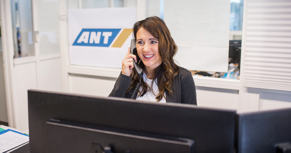 Svenja Behrens Teamassistenz am Schreibtisch mit Telefonhörer am Ohr